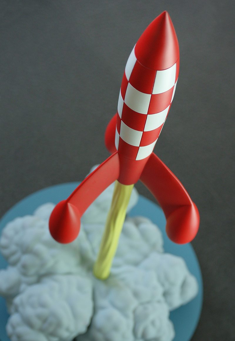 A model of a red and white chequered rocket lifting off